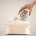 a hand holding arista shampoo bar tin box