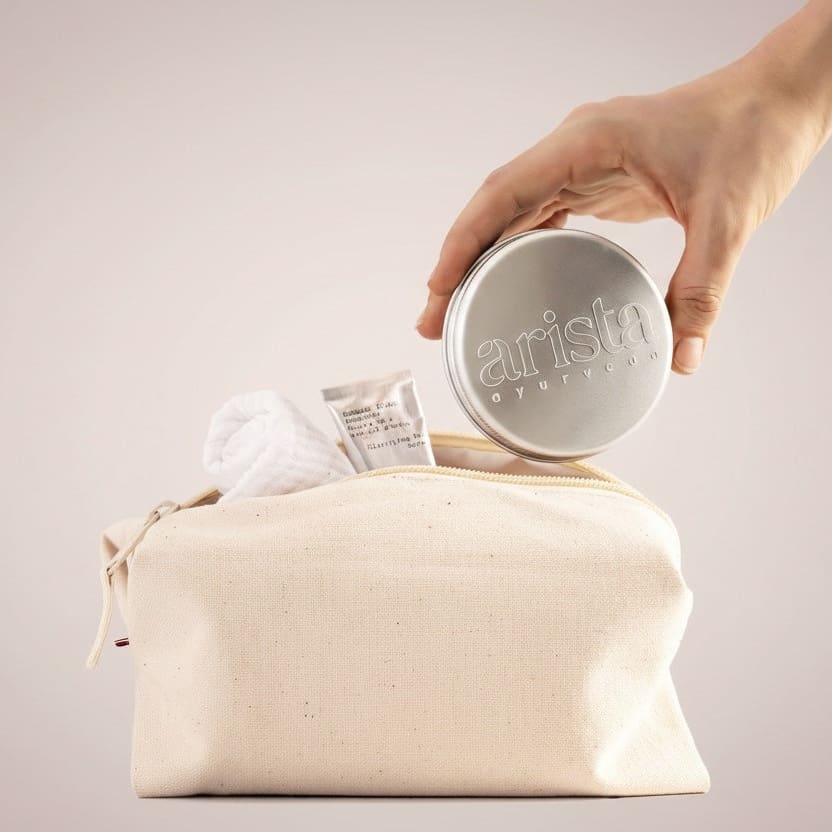 a hand holding arista shampoo bar tin box